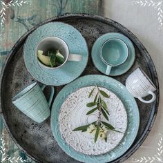 a tray with plates, cups and saucers on it