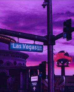 the street sign for las vegas blvd is lit up in purple and pink