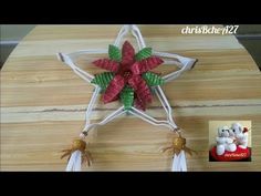 an ornament made out of paper on top of a wooden table with tassels