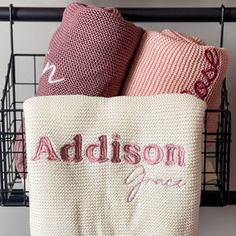 two towels sitting on top of each other in a basket next to a towel rack