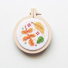 a cross - stitch hoop hanging on a white surface