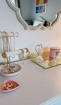 a bathroom vanity with jewelry on it and a mirror