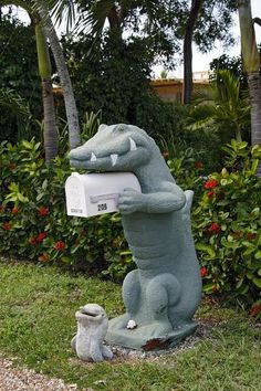 a statue of a crocodile holding a mail box