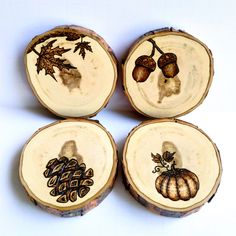 four pieces of wood with different designs on them, including acorns and leaves