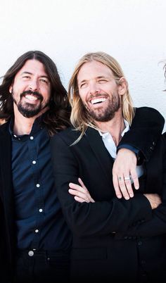 three men standing next to each other smiling