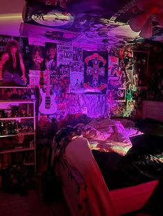 a bedroom with purple lighting and posters on the wall