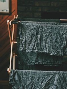 an ironing board with two linens hanging from it's sides, in front of a brick wall