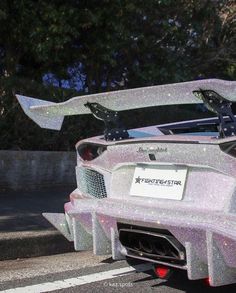 a silver sports car parked on the side of the road