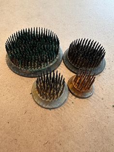 three different sized hair brushes sitting on top of a counter next to each other,