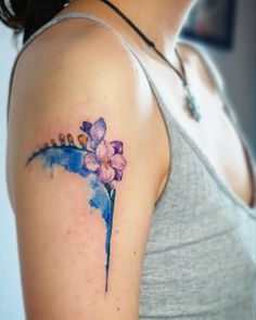 a woman's arm with a flower tattoo on the left side of her arm