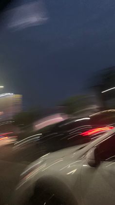 blurry photograph of cars driving down the road at night