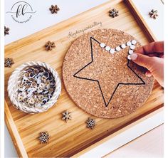 someone is making a star decoration on a cork board