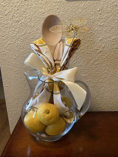 a glass vase filled with lemons and wooden spoons