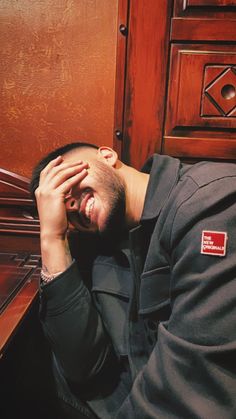 a man is sitting on the floor with his head in his hands and eyes closed