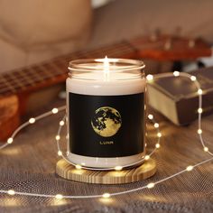 a candle sitting on top of a table next to a string of lights and a guitar