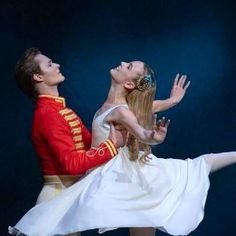 a man and woman dressed in red are performing on stage with one holding the other's leg