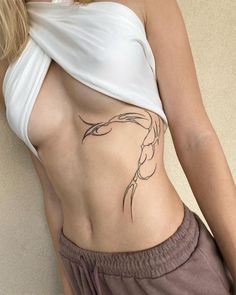 a woman's stomach with a tattoo on her left side and the bottom part of her body