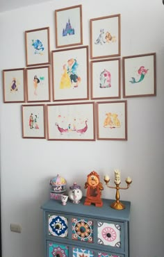 a dresser with many pictures on the wall above it and an animal figurine