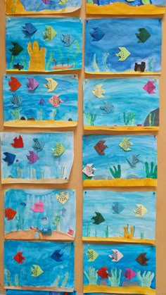 some fish are hanging on the wall in front of blue water and yellow frames with different colors