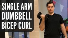 a man holding two dumbbells while standing in front of a sign that says single arm dumbbell bice curl