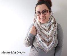 a woman wearing glasses and a crocheted scarf