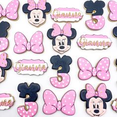 minnie mouse cookies decorated with pink and blue icing are displayed on a white surface