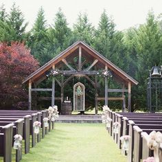 an outdoor wedding venue with rows of pews