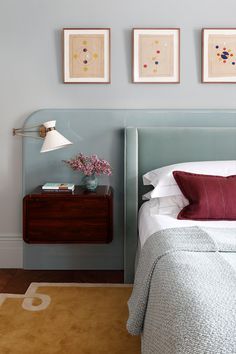 a bedroom with two framed pictures above the bed