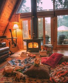 a dog laying on a pillow in the middle of a living room with a fireplace