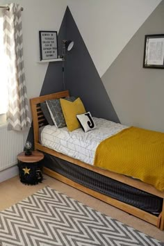 a bedroom decorated in gray and yellow with a chevron rug on the floor next to the bed