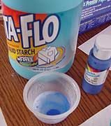 two buckets of blue liquid sitting on top of a table next to other items