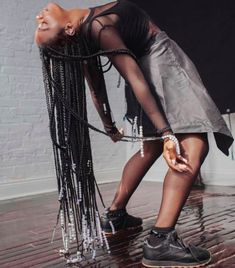 a woman is standing on a skateboard with chains attached to her legs and wearing black shoes