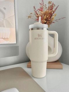 a white coffee cup sitting on top of a desk