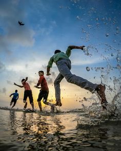 three young men are playing in the water