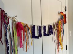 there are many ribbons hanging on the wall next to the door that is decorated with beads