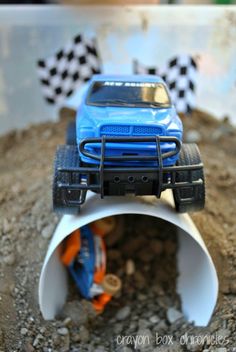 a blue toy truck is stuck in a pipe