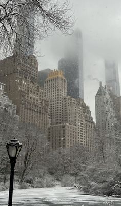 the city skyline is covered in snow and fog