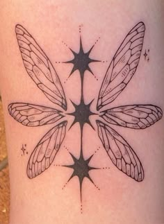 a tattoo on the leg of a woman with three stars and two dragonflies in it