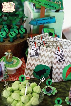 a table topped with bags filled with green treats