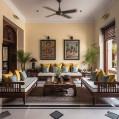 a living room filled with lots of furniture and paintings on the wall above it's windows