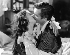 a man kissing a woman on the cheek in a scene from the film, my fair lady