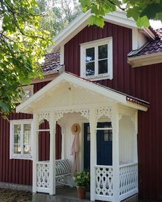 a small red and white house with a porch