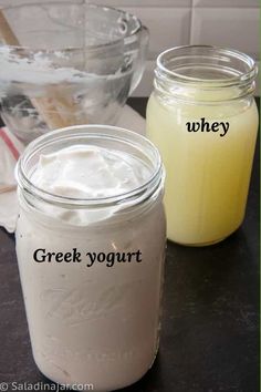 two jars filled with yogurt sitting on top of a counter