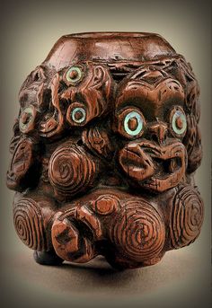 an intricately carved vase with eyes on it