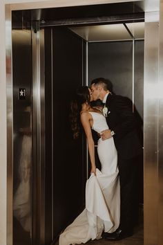 a bride and groom kissing in an elevator