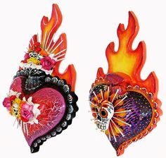 two decorative heart shaped objects with flames and skulls on them, one in the shape of a flaming heart