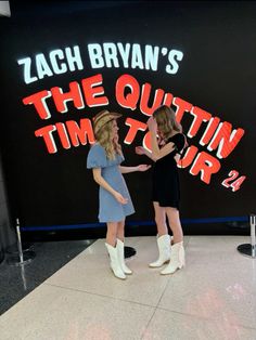 two women standing in front of a sign that says, the quitin'time tour