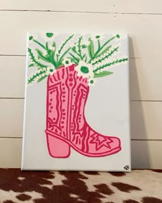 a pink boot with flowers on it sitting on a cow print rug in front of a white wall