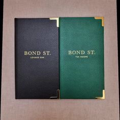 two black and green binders with gold lettering on the front one is for bond st