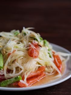 a white plate topped with noodles and veggies